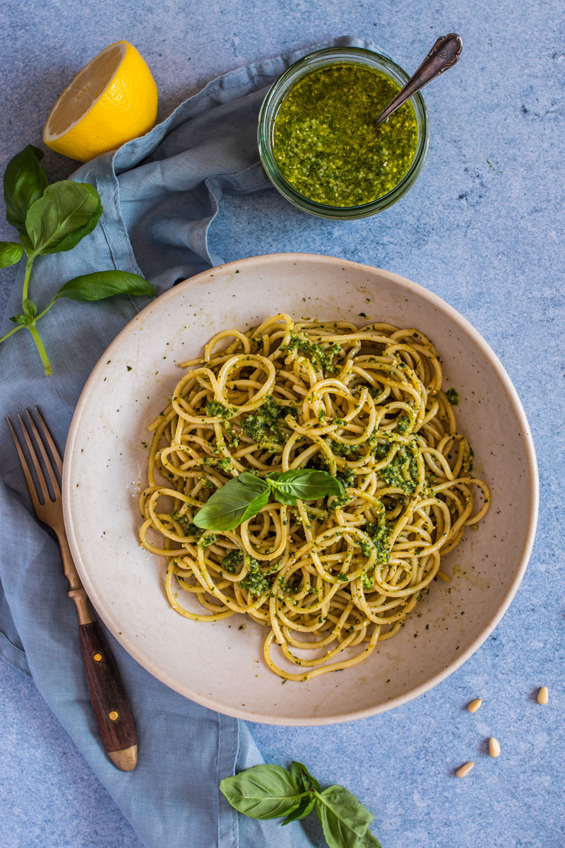 Basilikum-Pesto mit Spaghetti auf einem hellen Teller