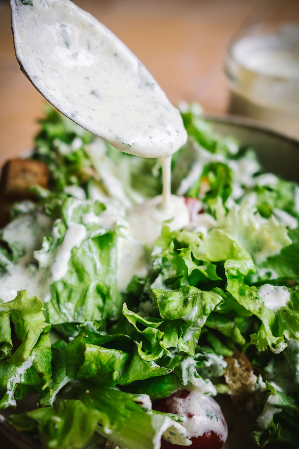Sahnedressing wird auf Salat gegeben