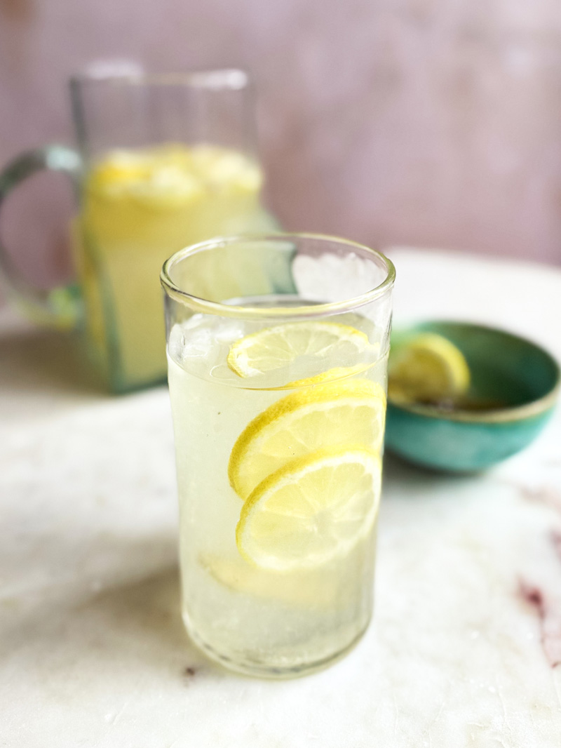 Pickle Lemonade im Glas mit Karaffe im Hintergrund