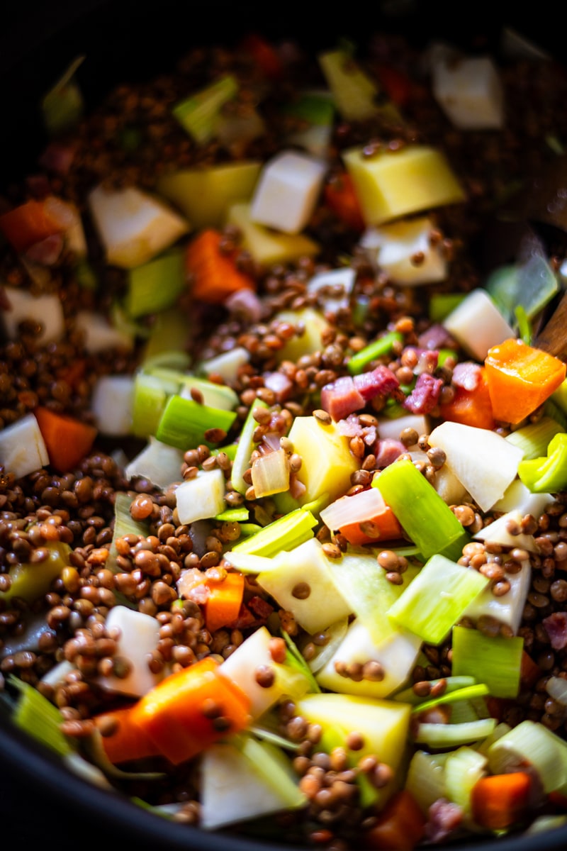 Zutaten für Linsensuppe mit Speck in einem Topf