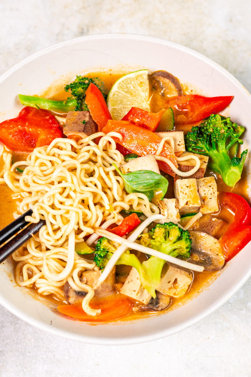 Thai-Kokos-Suppe mit Nudeln und Gemüse nah fotografiert