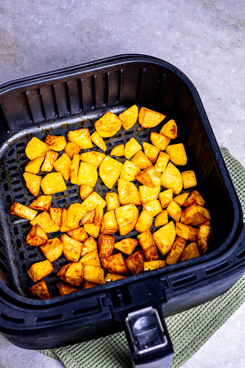 Goldgelbe Bratkartoffeln im Garkorb der Heißluftfritteuse