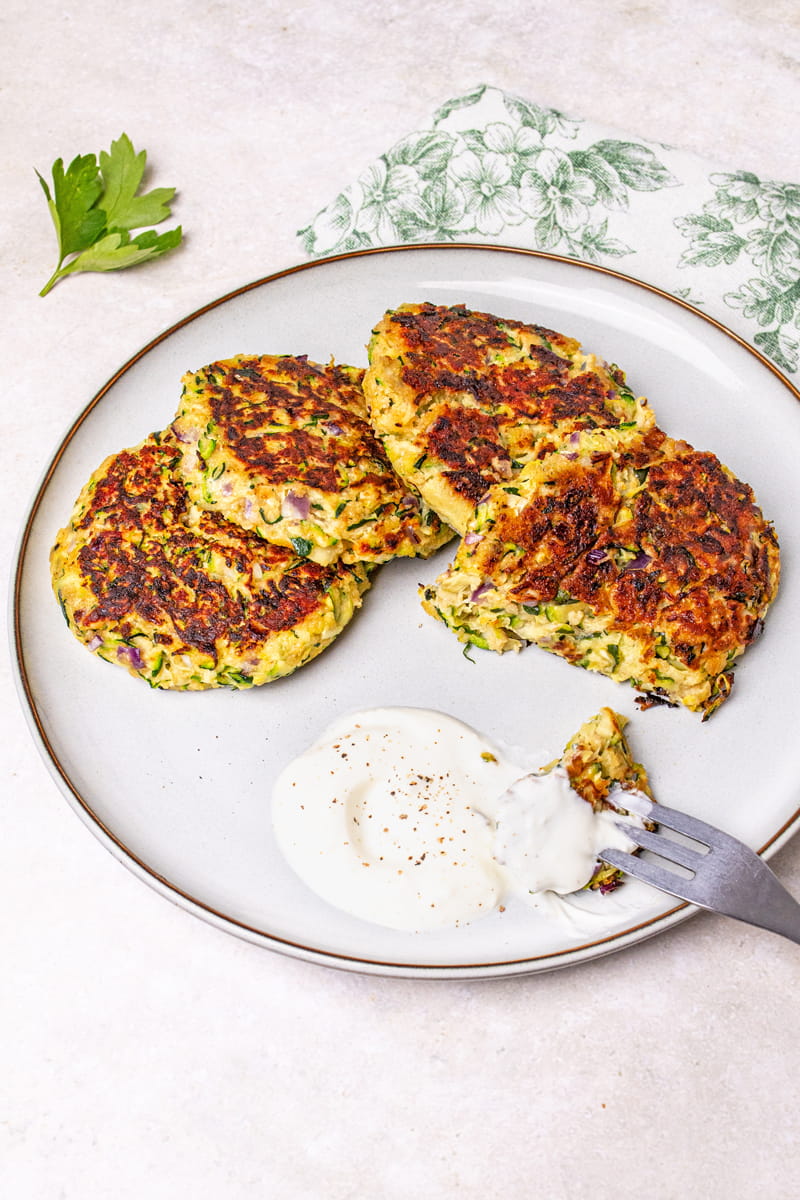 Zucchinipuffer mit Dip auf Teller angerichtet